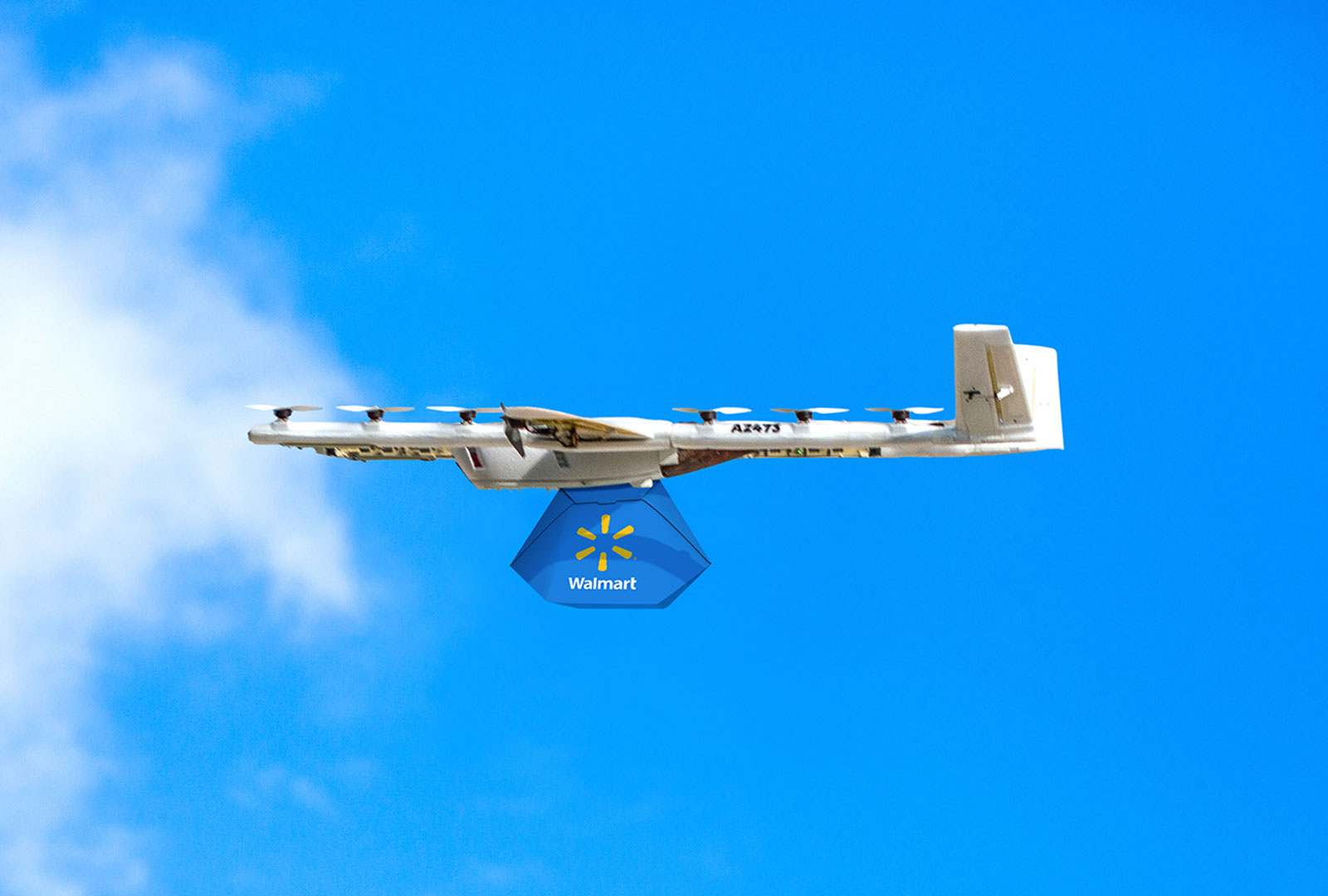 Dron wzlatuje z platformy startowej niosąc kolorową paczkę