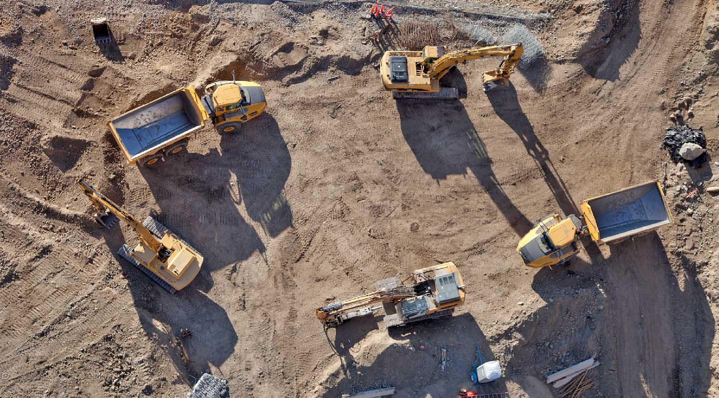 Supervisor na placu budowy porównuje harmonogram prac z pozycjami maszyn GPS