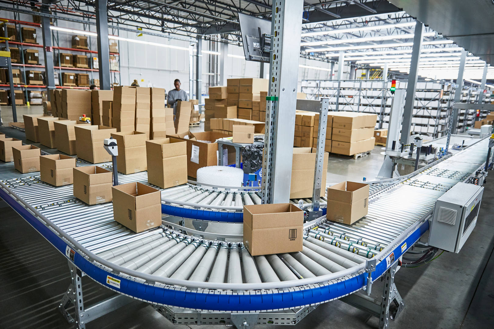 Monitor komputera z mapą śledzenia przesyłek leków obok pracownika w magazynie