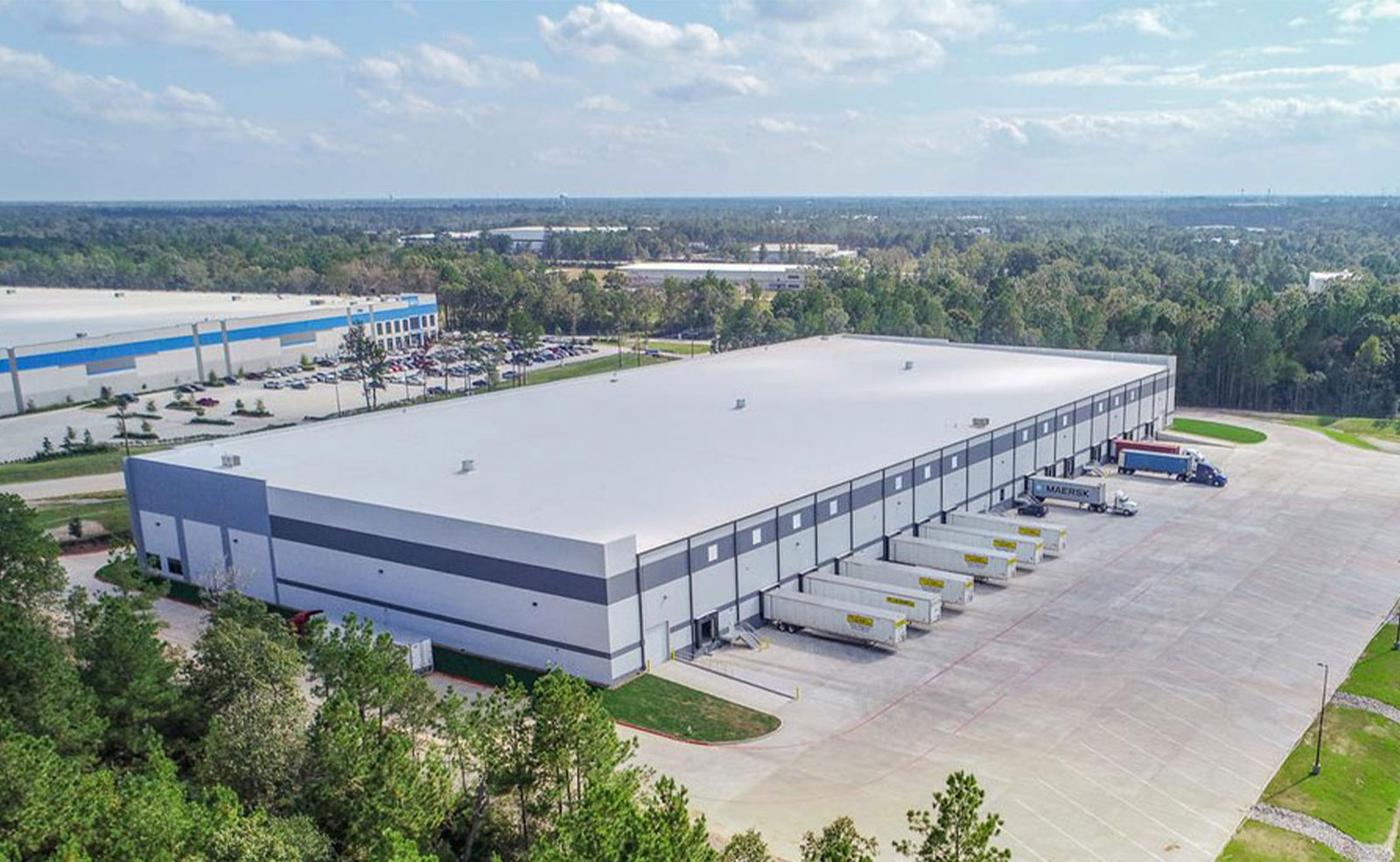 Mechanik naprawia ciężarówkę floty własnej w warsztacie przy magazynie firmowym