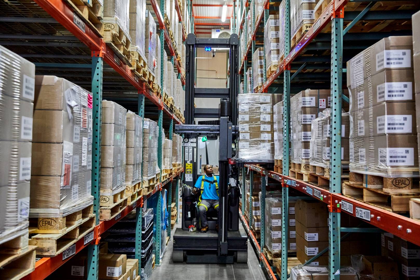 Mały zespół pakuje zamówienia w firmowym warsztacie wysyłkowym z taśmociągiem